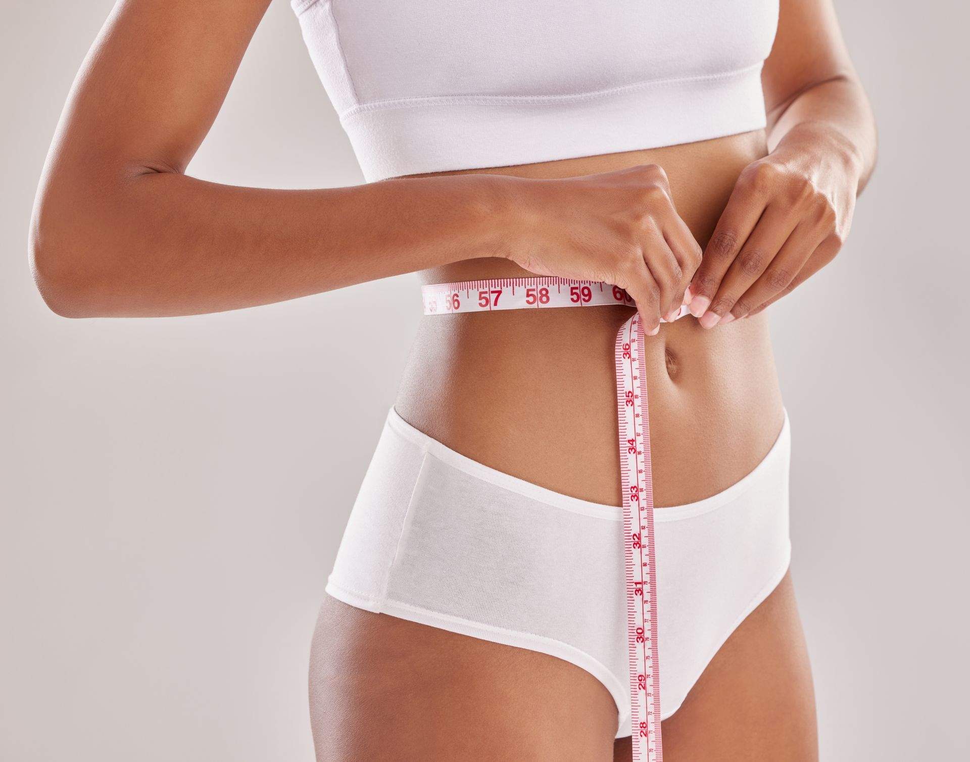 A woman in white underwear is getting her stomach examined by a doctor.