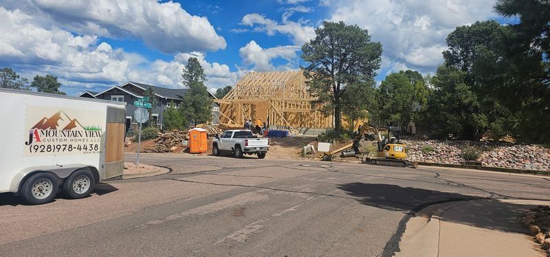 Construction site with a white truck, wooden framing, and workers on a sunny street