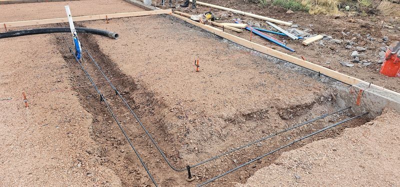 Construction site with a large rectangular dug-out area and tools along the edges