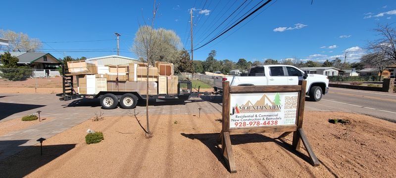 Trailer loaded with boxes beside a roadside sign under a clear blue sky