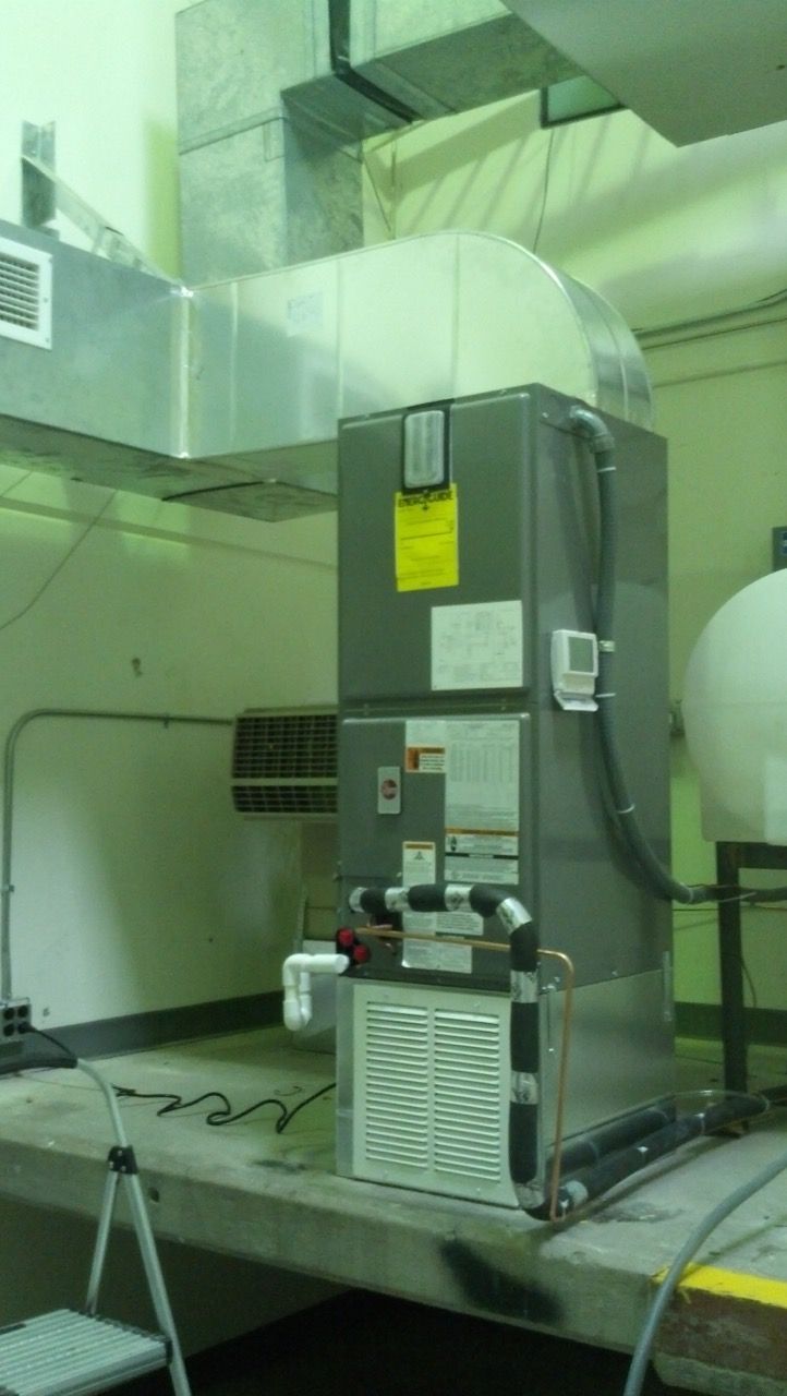 A large air conditioner is sitting on top of a table in a room.