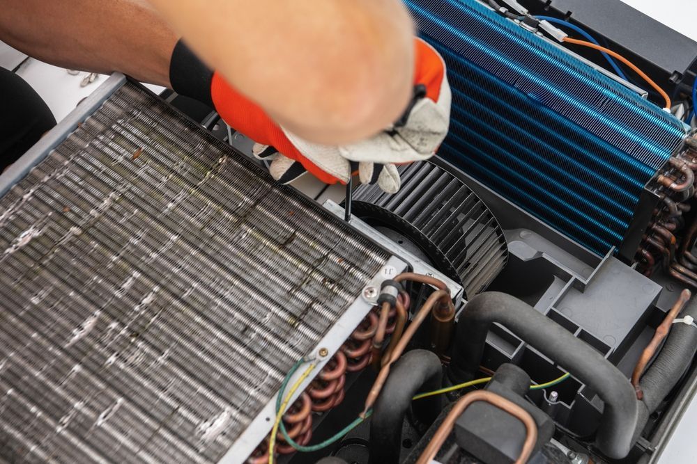 Gloved hands repairing car engine components under the hood.
