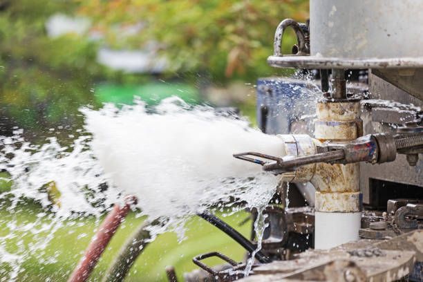Close-up image of the process and equipment of drilling a new residential water well. This image shows water forcefully spraying out of the new pcv water pipe