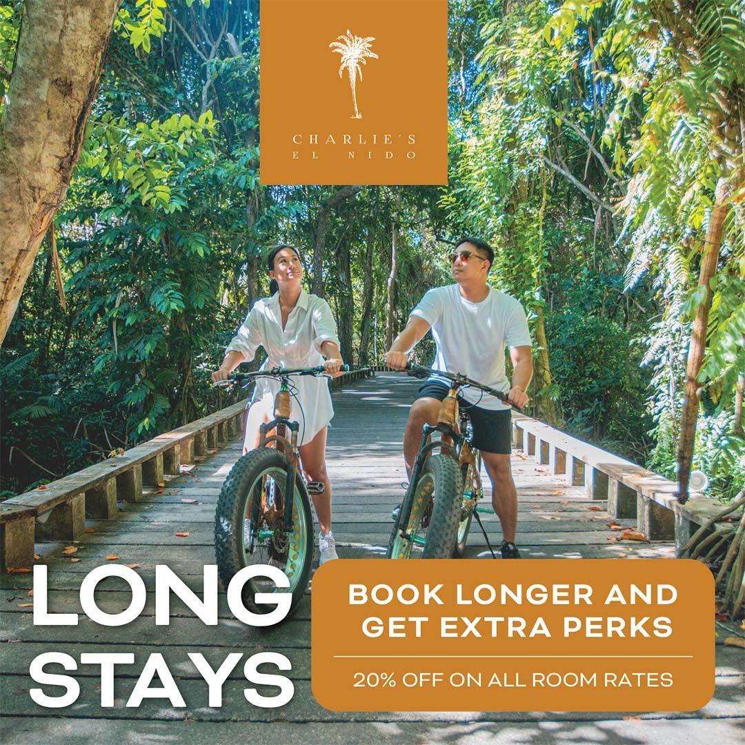 Two cyclists ride a lush forest bridge with “LONG STAYS” and “BOOK LONGER AND GET EXTRA PERKS” text.