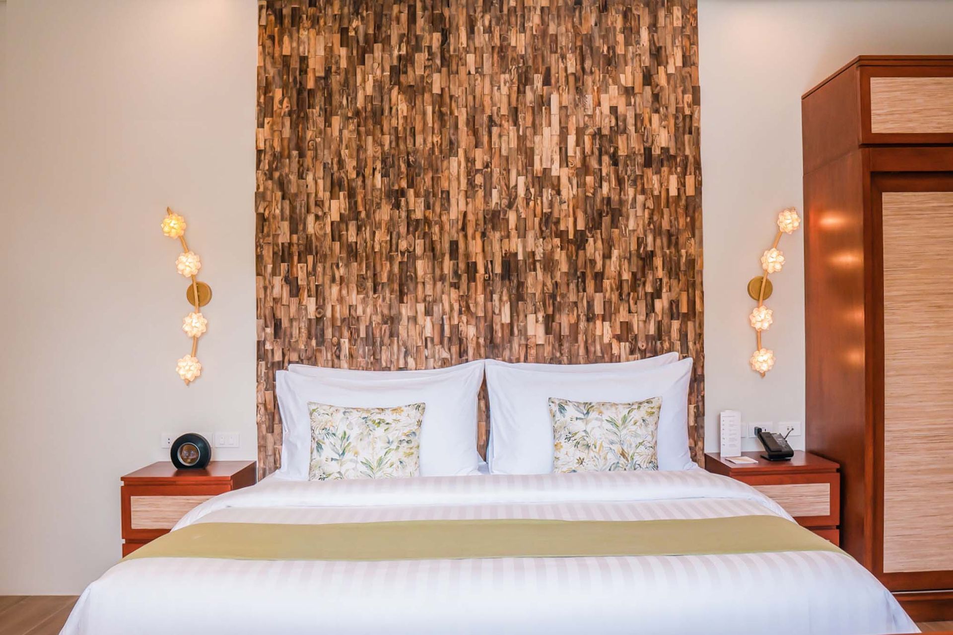 Cozy bedroom with natural woven headboard and white linens in a tropical resort.
