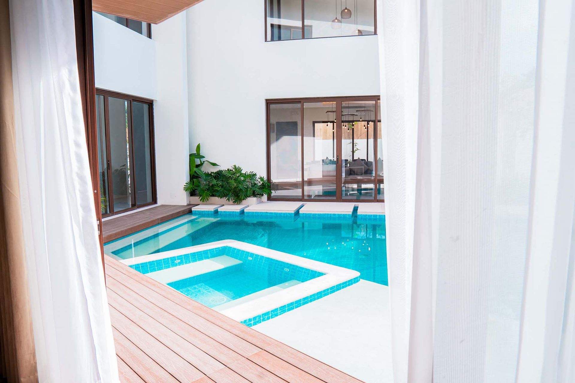 Indoor swimming pool with natural lighting from large windows and minimalist design