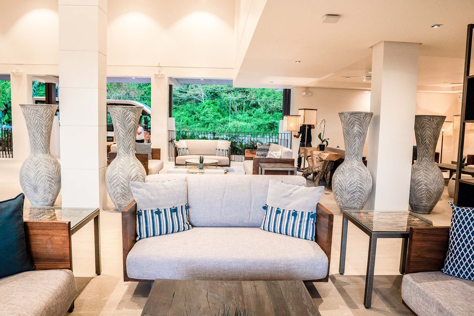 Charlie's El Nido lobby with gray sofas, blue pillows, and tall decorative 