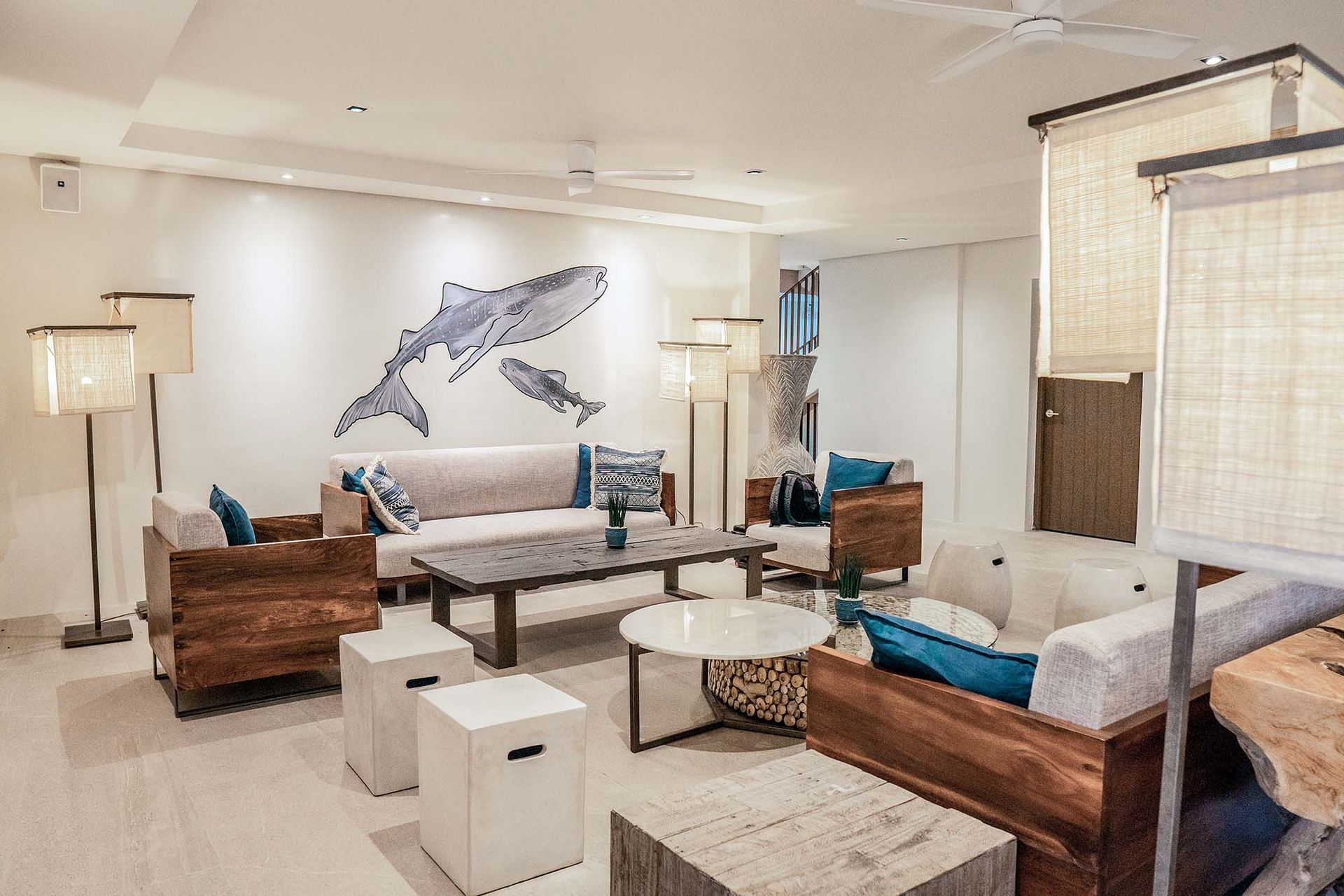 A living room filled with furniture and a painting of a whale on the wall.