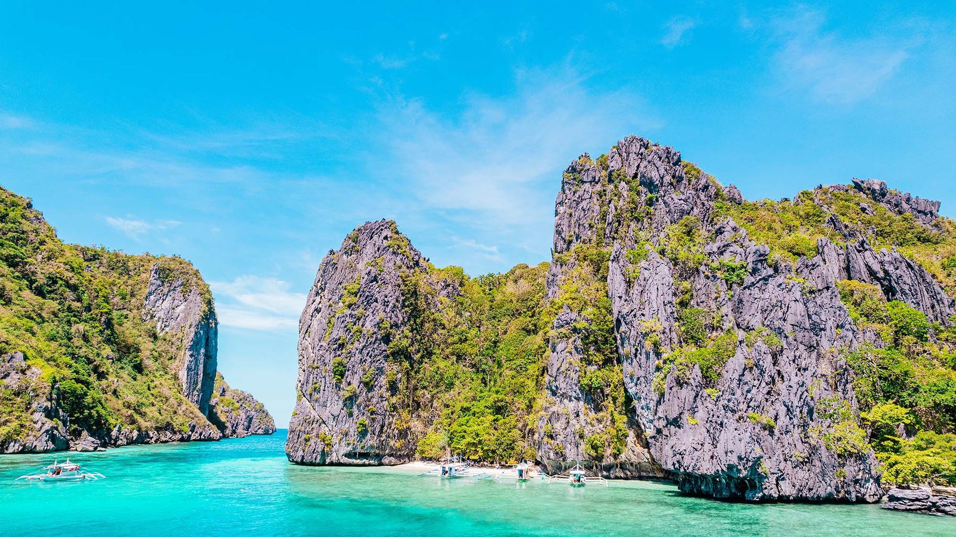 Turquoise lagoon with towering limestone cliffs in El Nido, Palawan