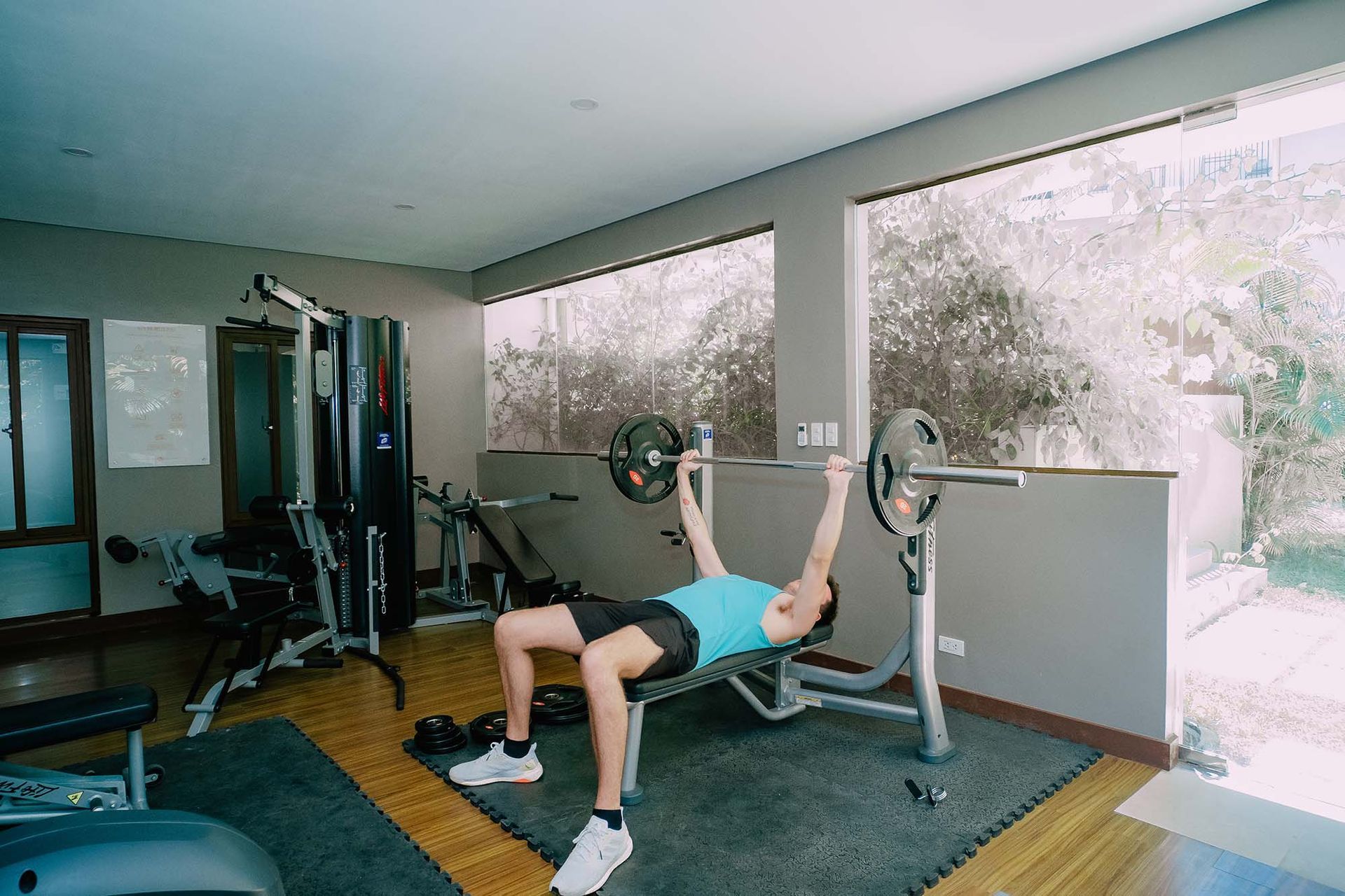 Man doing barbell bench press in Charlie's El Nido hotel gym