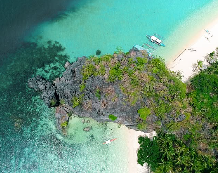 Aerial view of rocky islet with turquoise waters at Charlie's El Nido