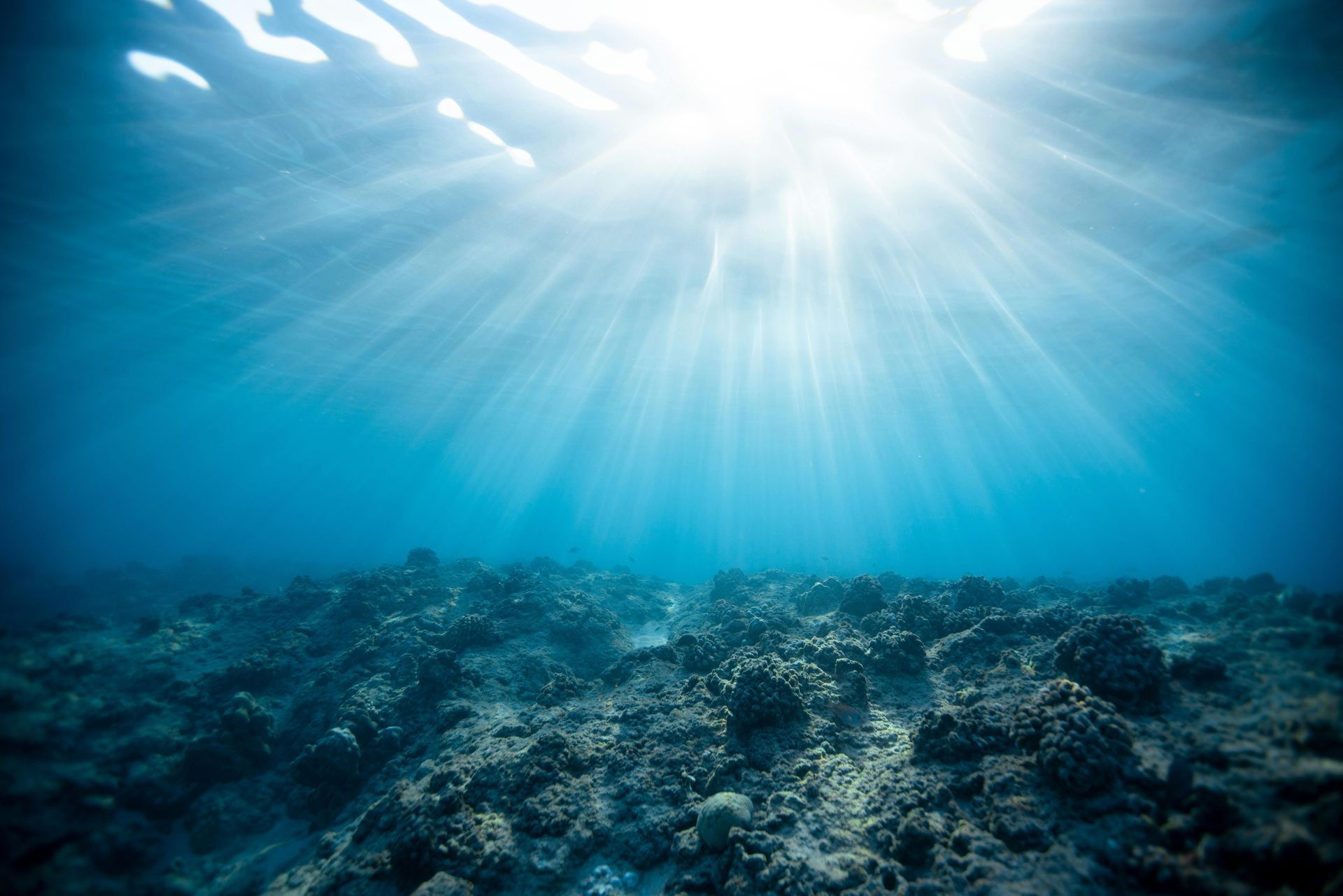 The sun is shining through the water in the ocean.