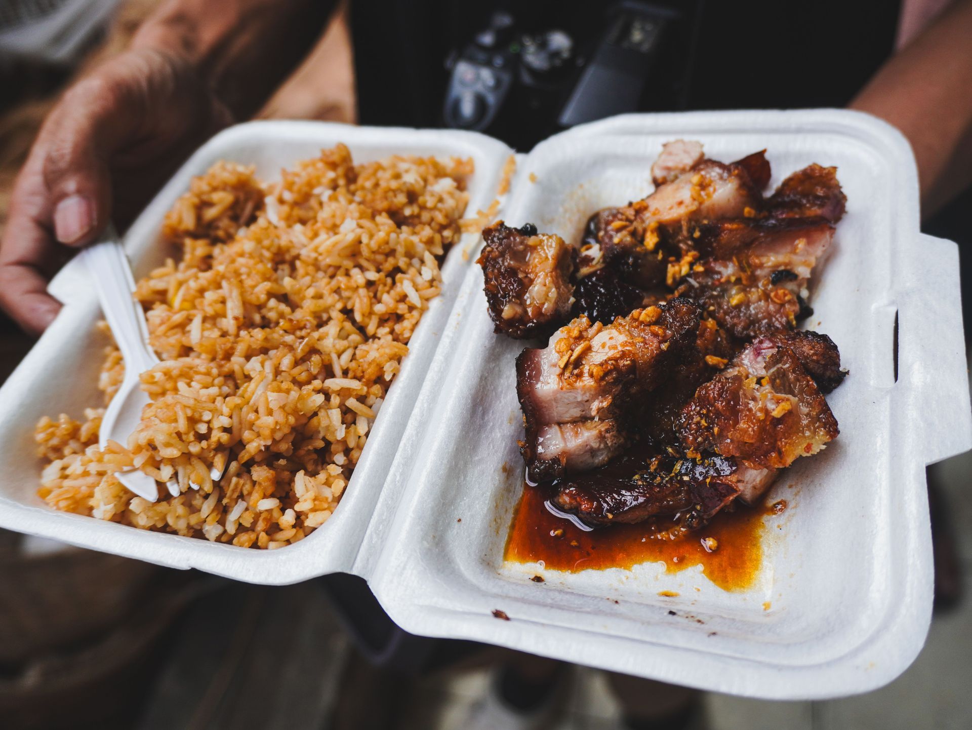 Takeout container with fried rice and glazed grilled meat