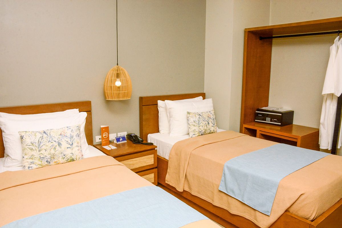 Cozy twin room at an El Nido hotel in Palawan featuring wooden furnishings and tropical-inspired decor