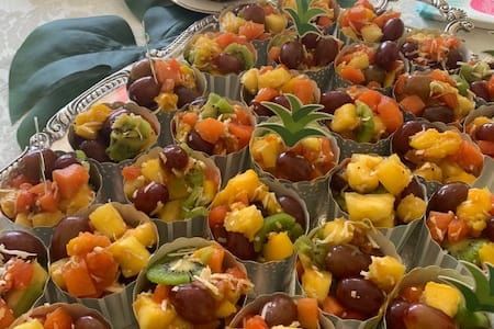 A tray of fruit cups filled with fruit and vegetables.