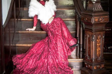 A woman in a red dress is sitting on a set of stairs.