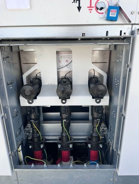 Open electrical cabinet with three switch units and wiring inside