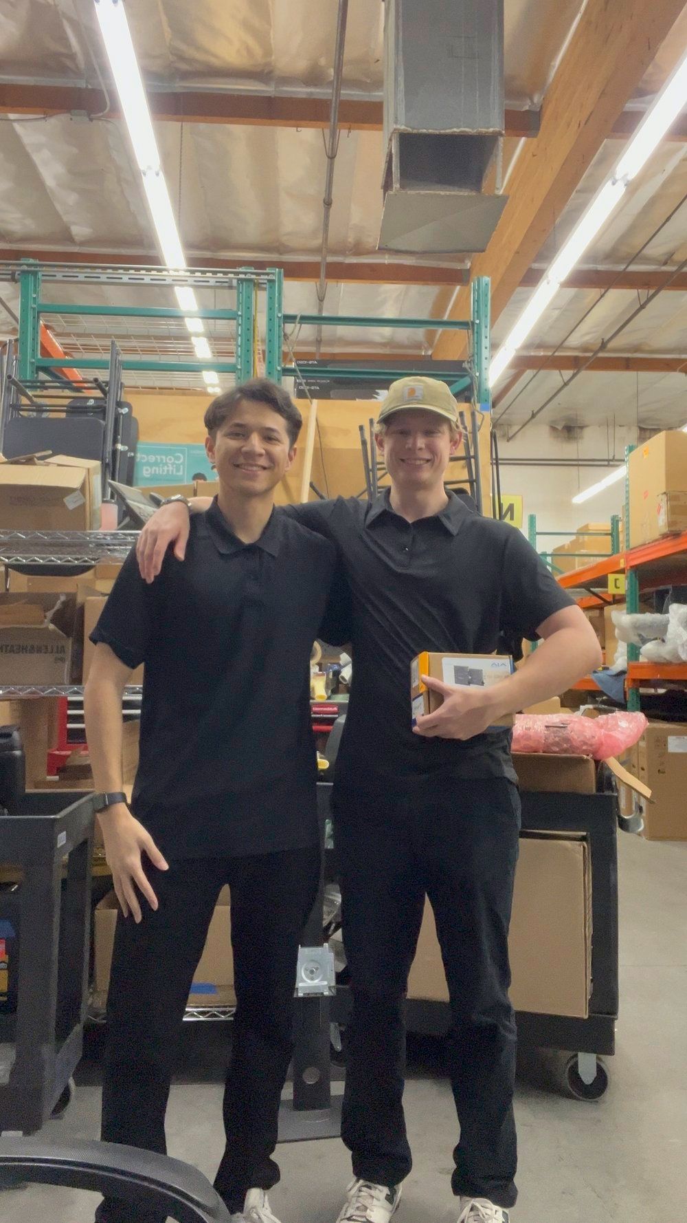 Two men are standing next to each other in a warehouse.