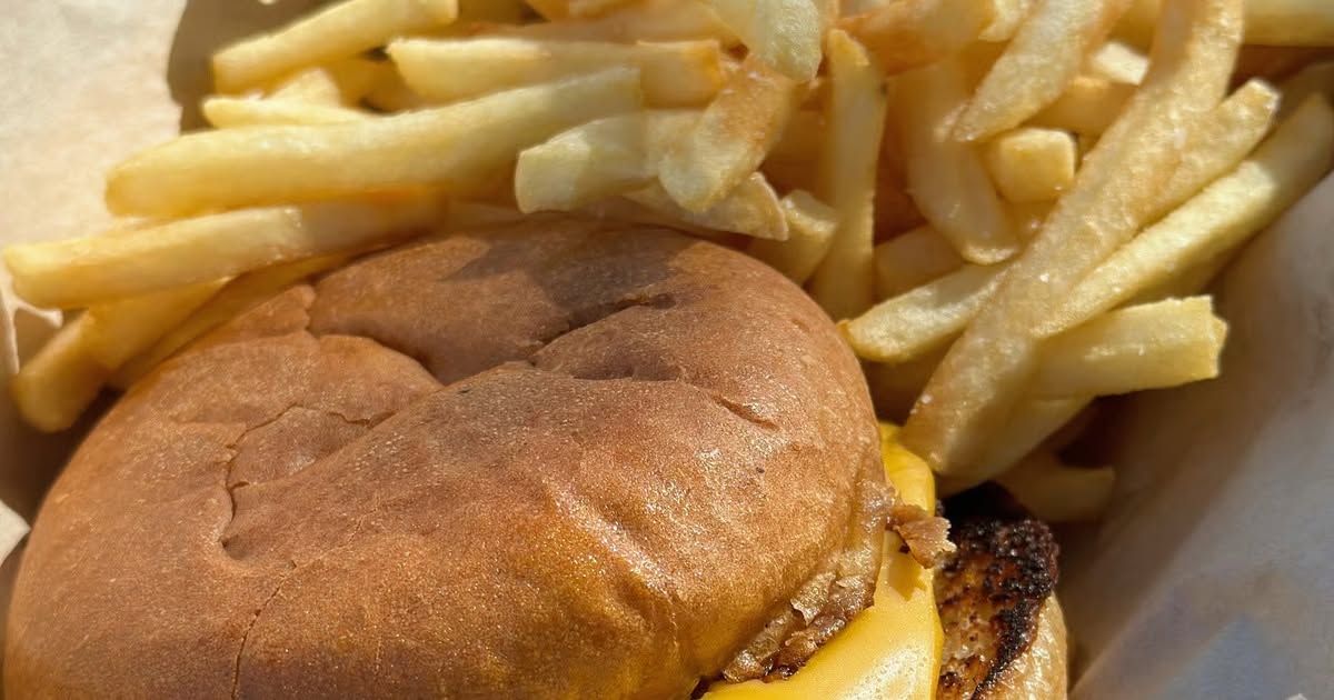 Burger and French fries in a paper takeout container