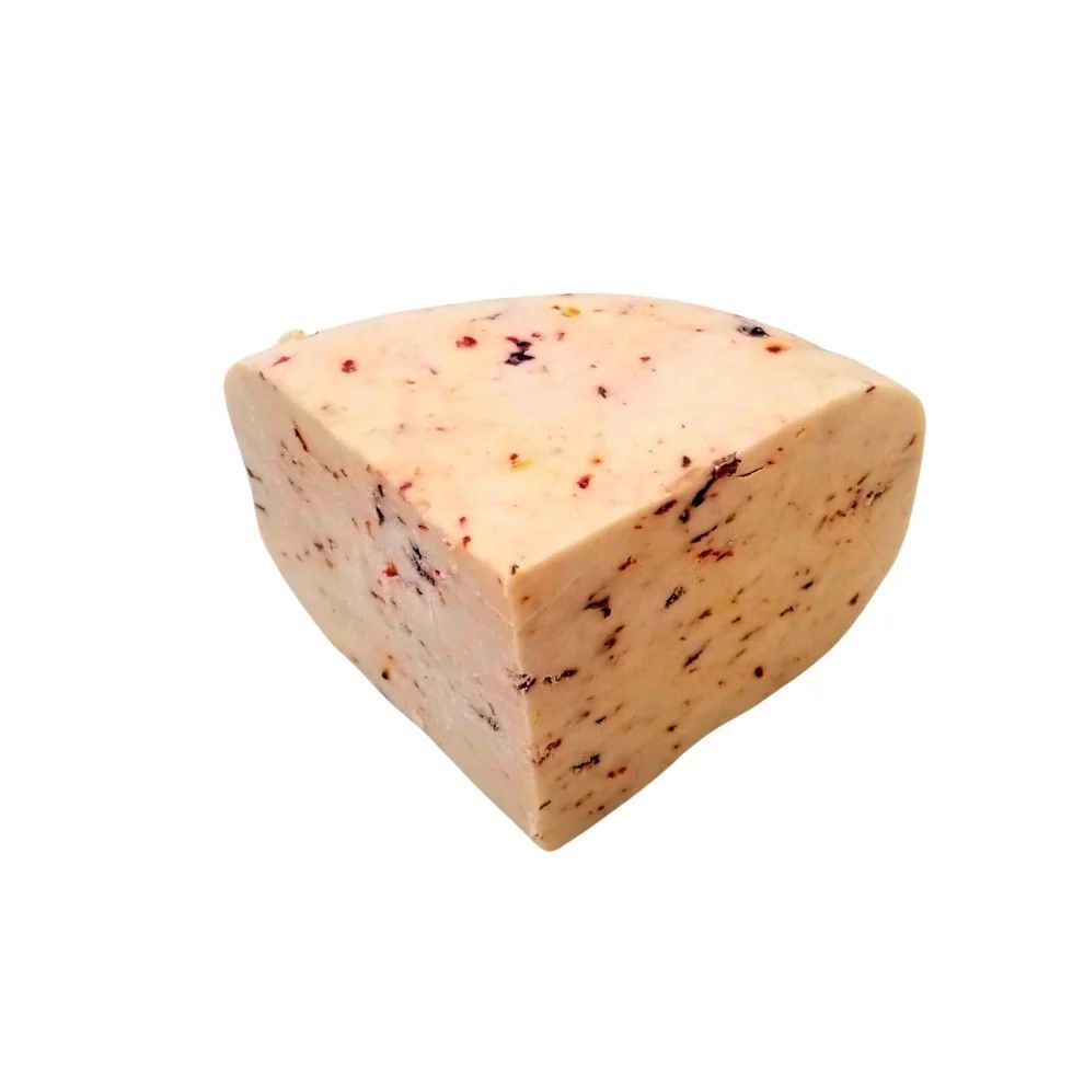 Wedge of pale cheese with red specks, isolated on a white background