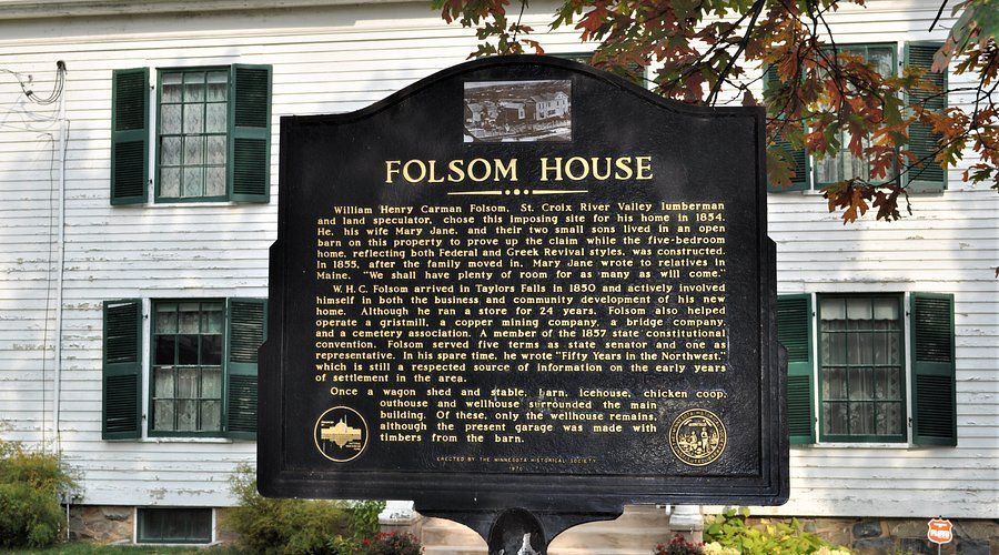 Folsom House historic marker in front of a white house with green shutters and autumn leaves