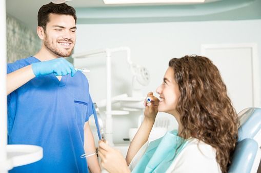 Dentist and patient smiling during a dental examination in a bright clinic