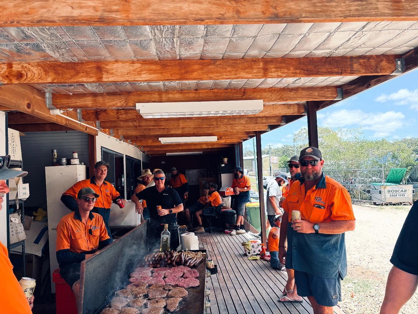 A Number Of Workers With High Vis Shirts On In Front Of A BBQ — Nambucca Plumbing in Nambucca Heads, NSW