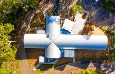 An Aerial View of A Large White Building Surrounded by Trees — Nambucca Plumbing in Nambucca Heads, NSW