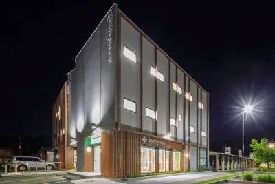 A Large Building with A Lot of Windows Is Lit up At Night — Nambucca Plumbing in Nambucca Heads, NSW