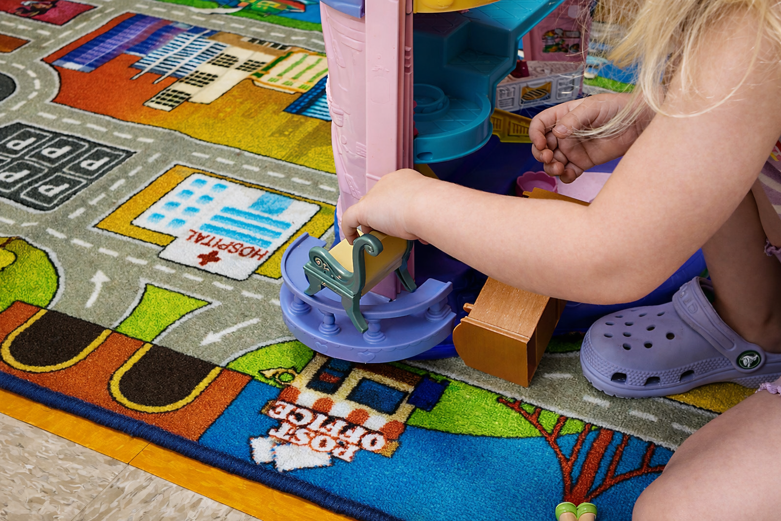 Child playing with a toy on a colorful patterned rug