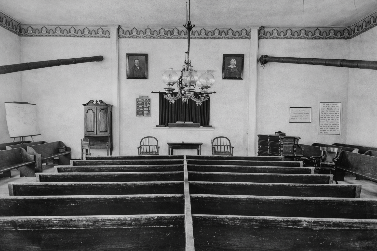 Black-and-white interior of a church sanctuary with pews facing the altar and pulpit