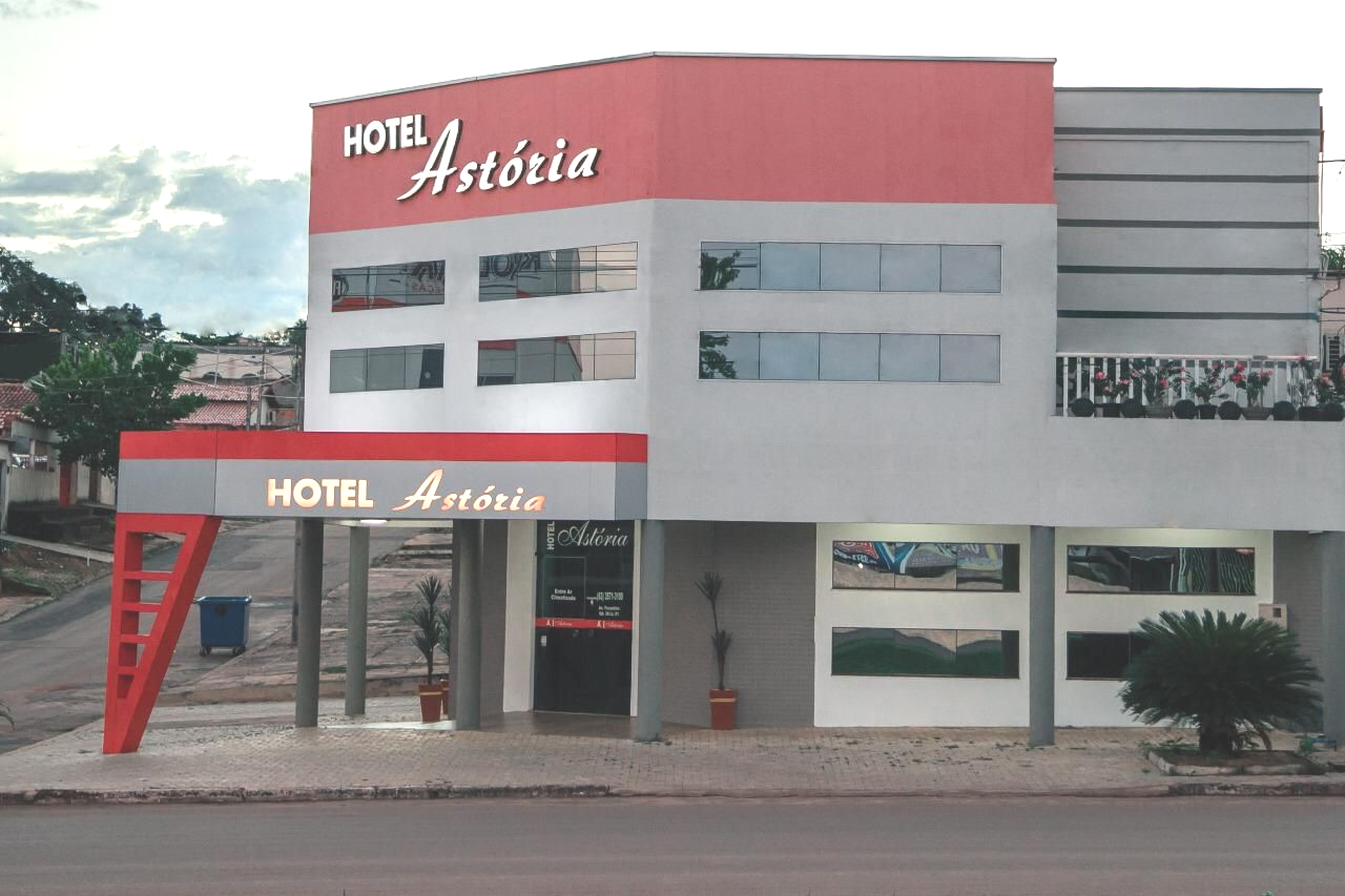Edifício do Hotel Astoria, exterior vermelho e cinza, placa acima da entrada.