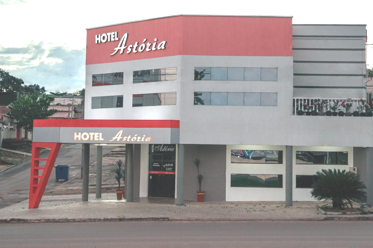 Edifício do Hotel Astoria, exterior vermelho e cinza, placa acima da entrada.