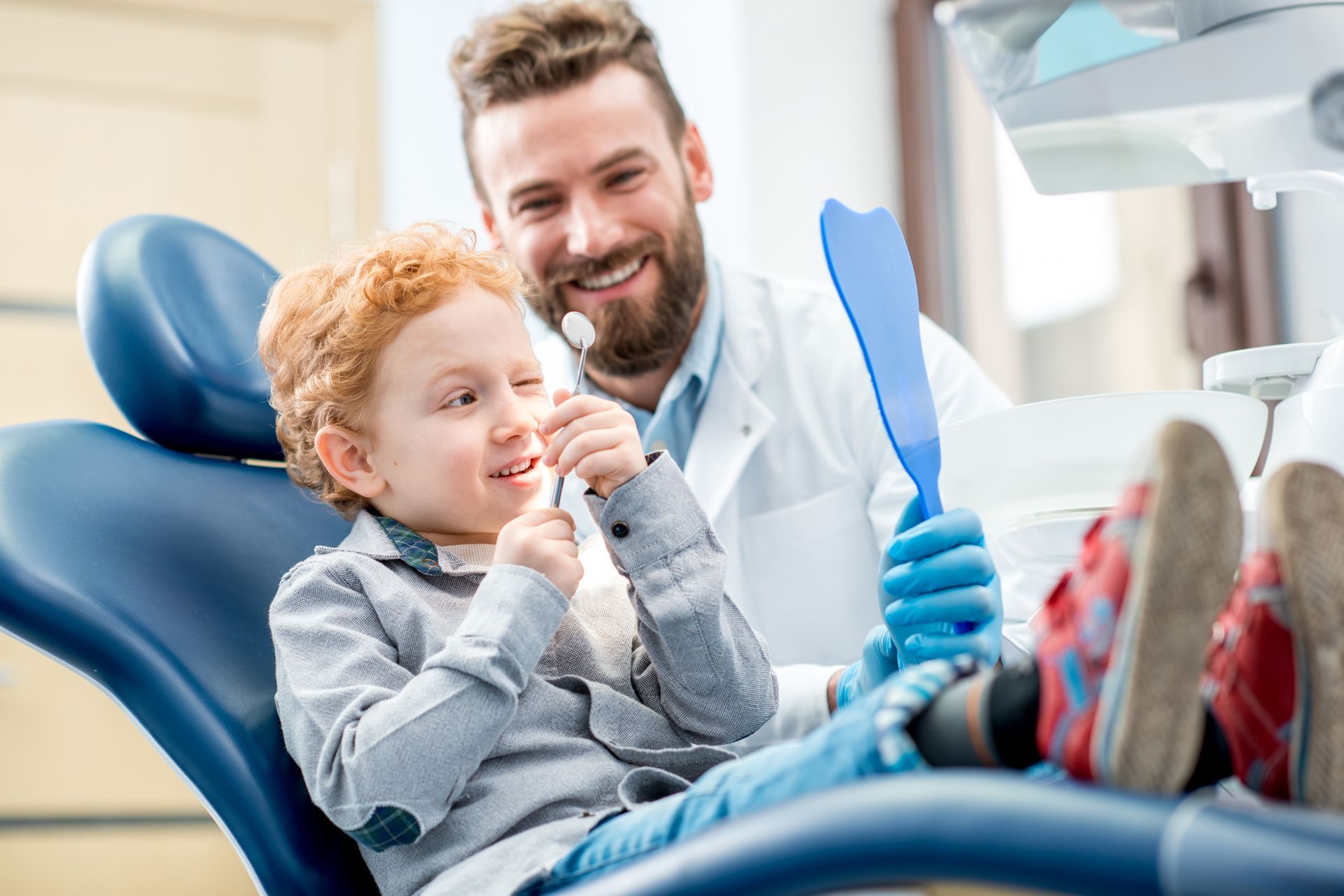 Kid playing with dental tool at kids dental office in Winston-Salem, NC, Kid Smiles.