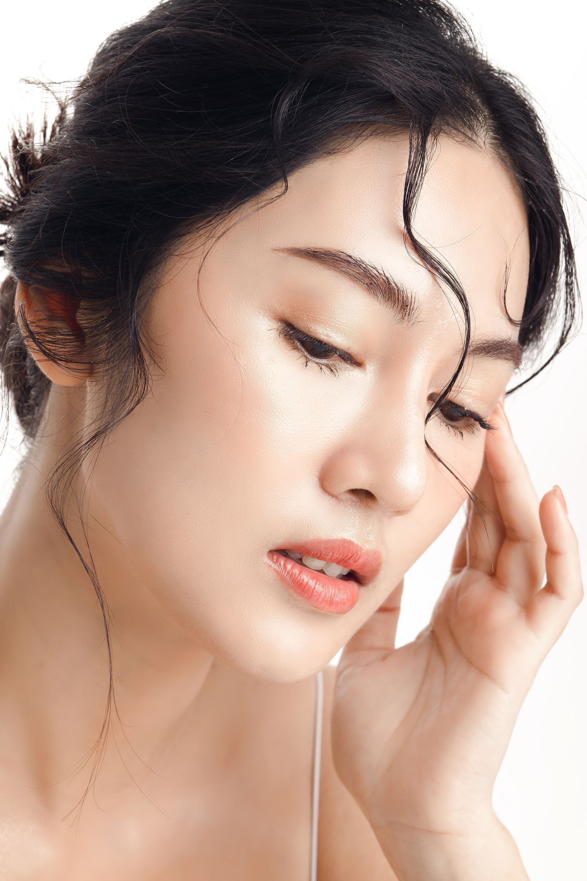 A close up of a woman 's face with her hand on her head.