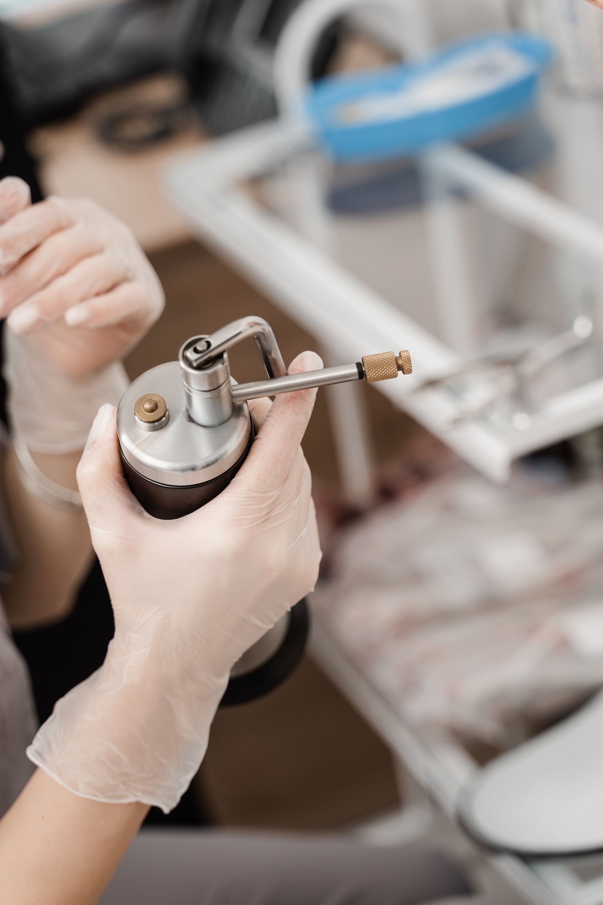 A woman wearing gloves is holding a machine in her hands.