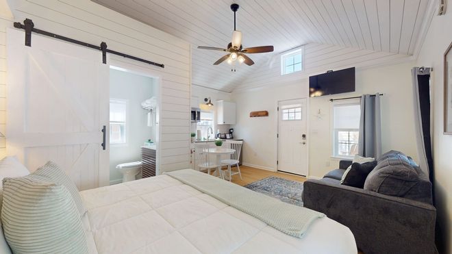 A bedroom with a king size bed , a nightstand , a table and a television.