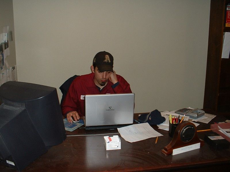 American Electric LLC | A man is sitting at a desk using a hp laptop