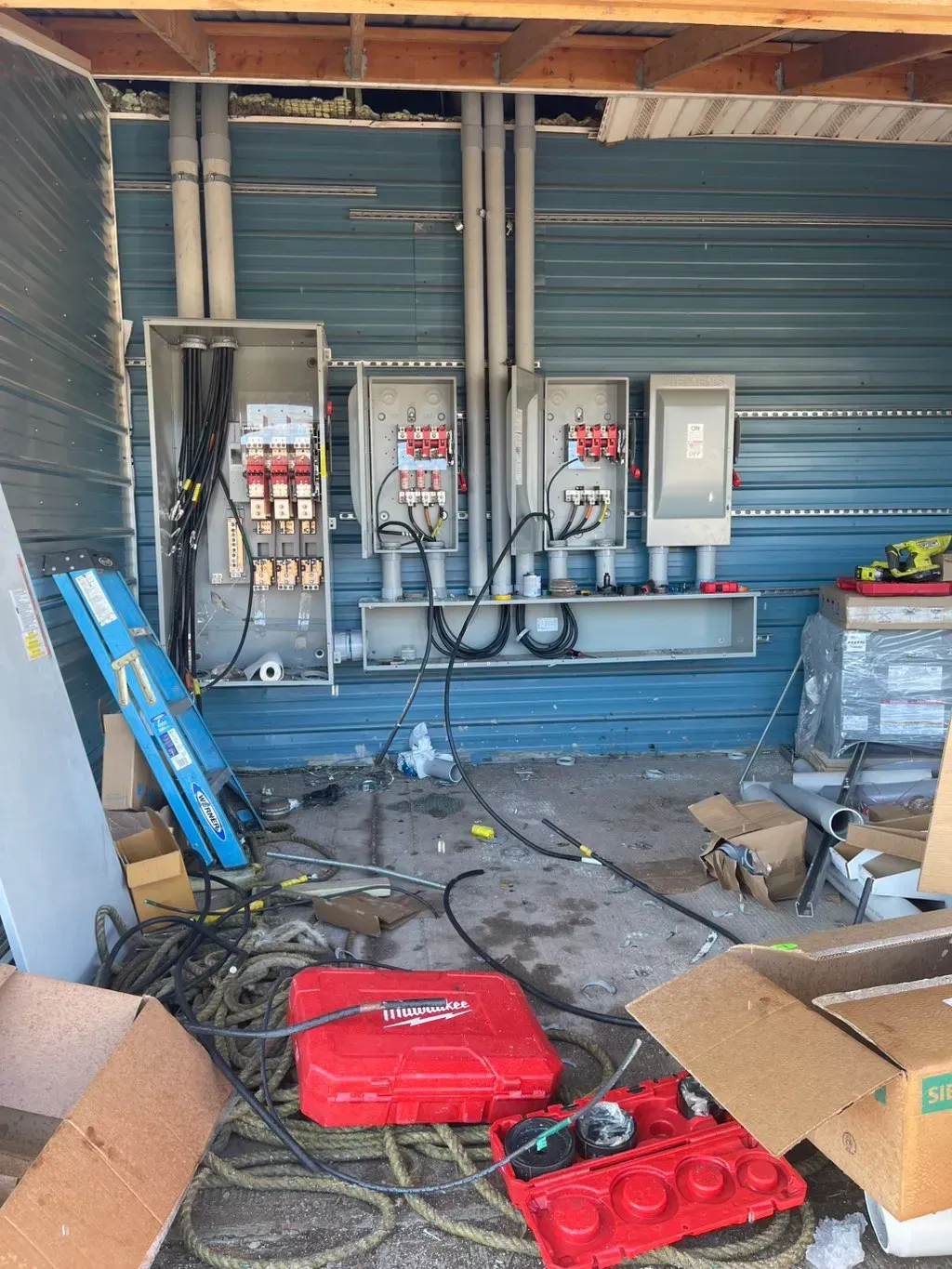 American Electric LLC | A room with a lot of electrical equipment and boxes on the floor.