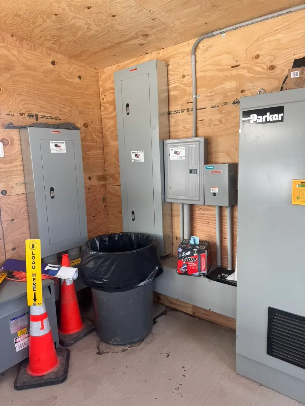 American Electric LLC | A room with a trash can and a sign that says