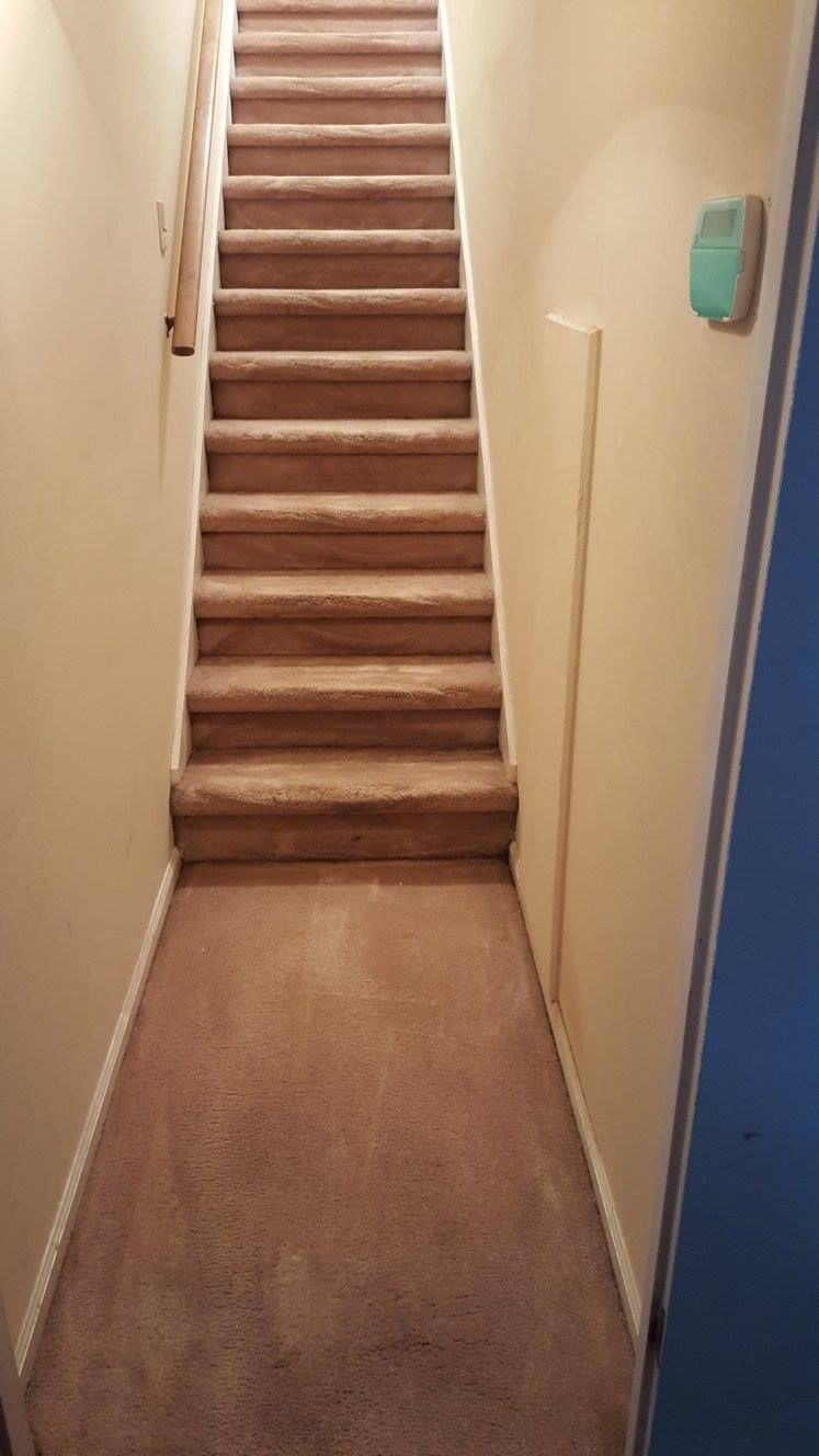 A door is open in a hallway with a carpeted floor.