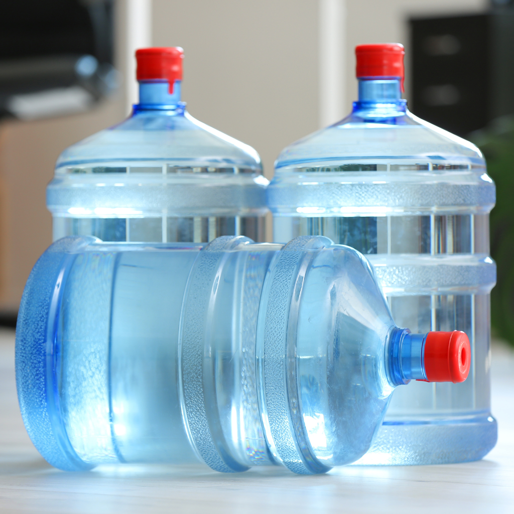 Nine different colored water bottles on a white surface, various colors, designs, and lids.