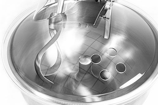 A close up of a stainless steel bowl with a spoon in it.