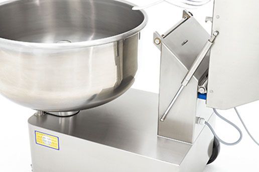 A stainless steel bowl is sitting on top of a machine.