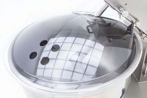 A close up of a stainless steel mixer with the lid open.