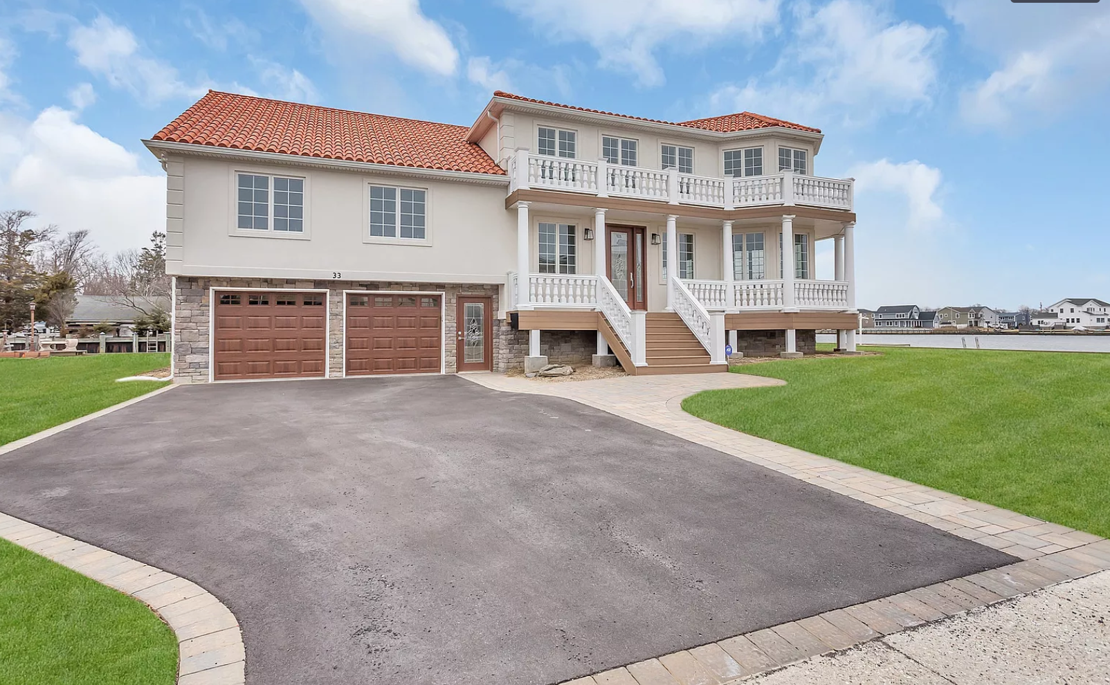 A large white house with a red tile roof is for sale