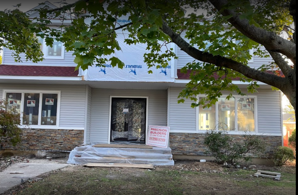 A house under construction with a tree in front of it.