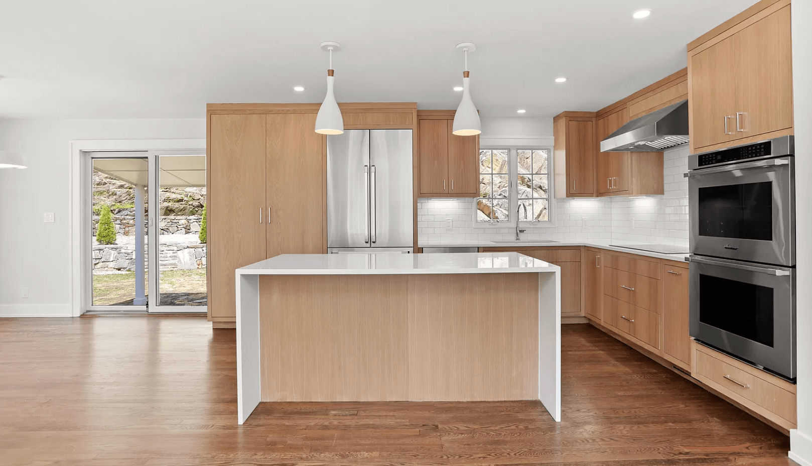 A kitchen with wooden cabinets , stainless steel appliances , and a large island.