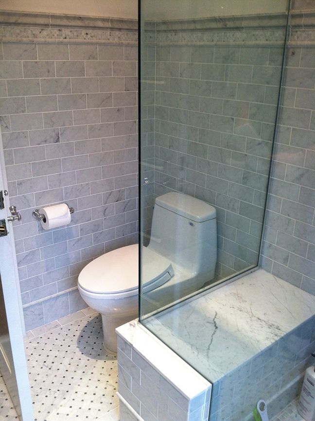 A bathroom with a toilet and a glass shower