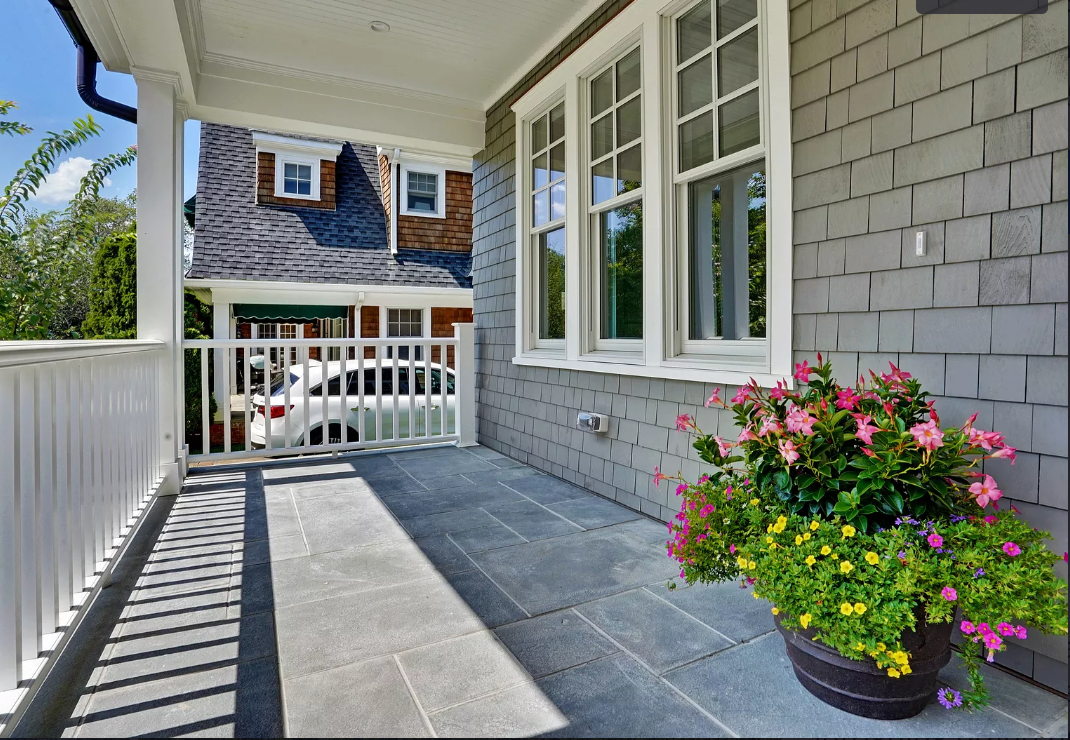 A porch with a pot of flowers on it